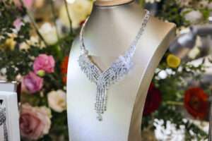 สร้อยคอเพชรดีไซน์หรูหราคอลเลกชันพิเศษ Viva Brilliance Bloom Collection จัดแสดงบนแท่นโชว์ท่ามกลางมวลพรรณไม้