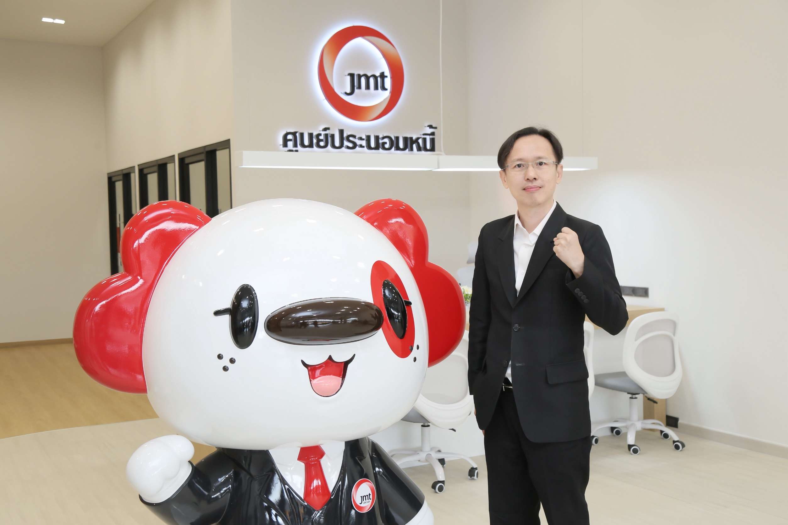 นายสุทธิรักษ์ ตรัยชิรอาภรณ์ ประธานเจ้าหน้าที่บริหาร JMT ถ่ายภาพร่วมกับมาสคอตประจำศูนย์ประนอมหนี้
