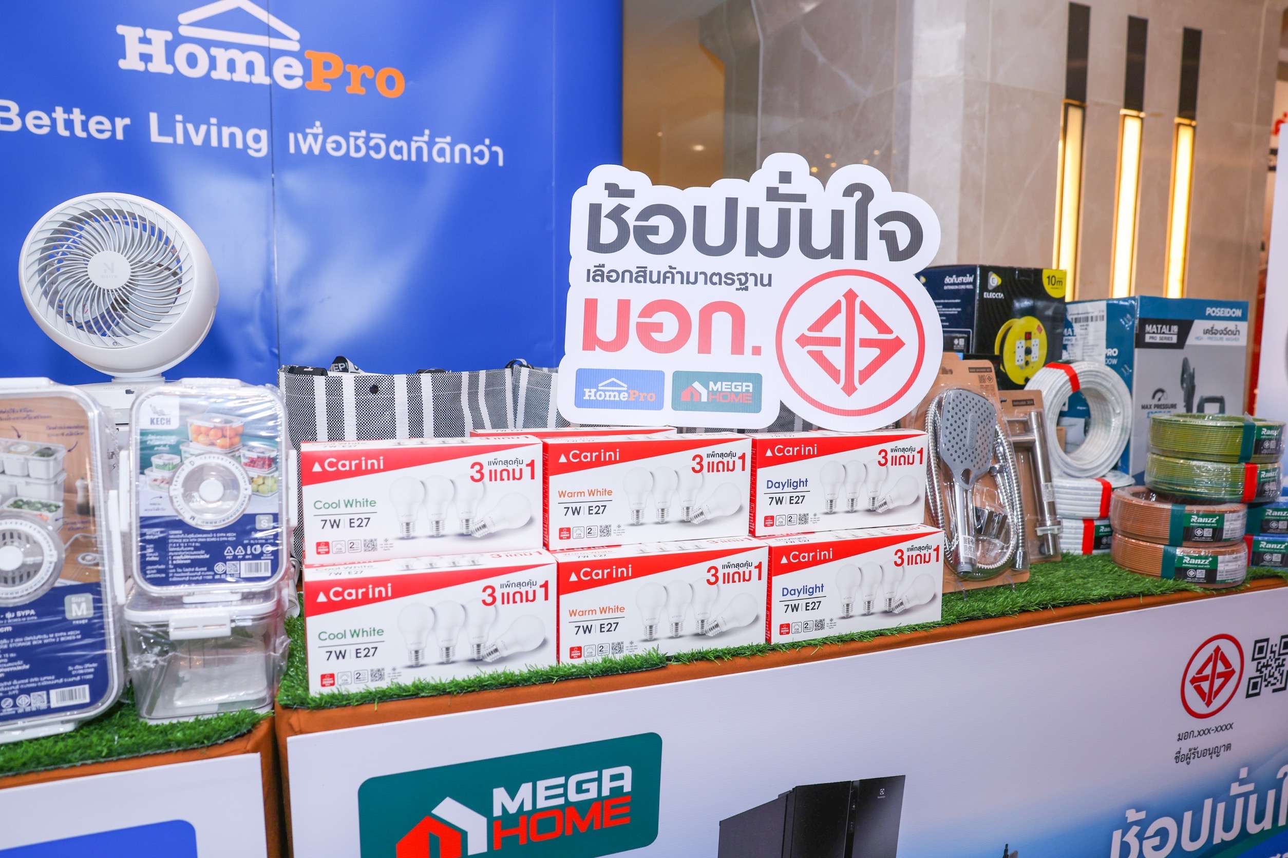 การจัดแสดงสินค้าที่ได้รับมาตรฐาน มอก. เช่น หลอดไฟ พัดลม และอุปกรณ์ช่าง พร้อมป้ายสัญลักษณ์ความร่วมมือระหว่างโฮมโปร เมกาโฮม และ สมอ.