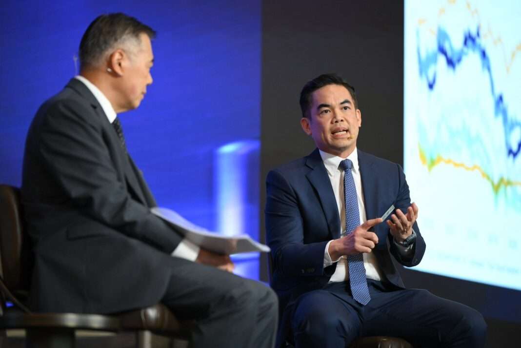 ดร.พิพัฒน์ เหลืองนฤมิตชัย ขณะกำลังบรรยายให้ข้อมูลด้านเศรษฐกิจและการลงทุนบนเวที