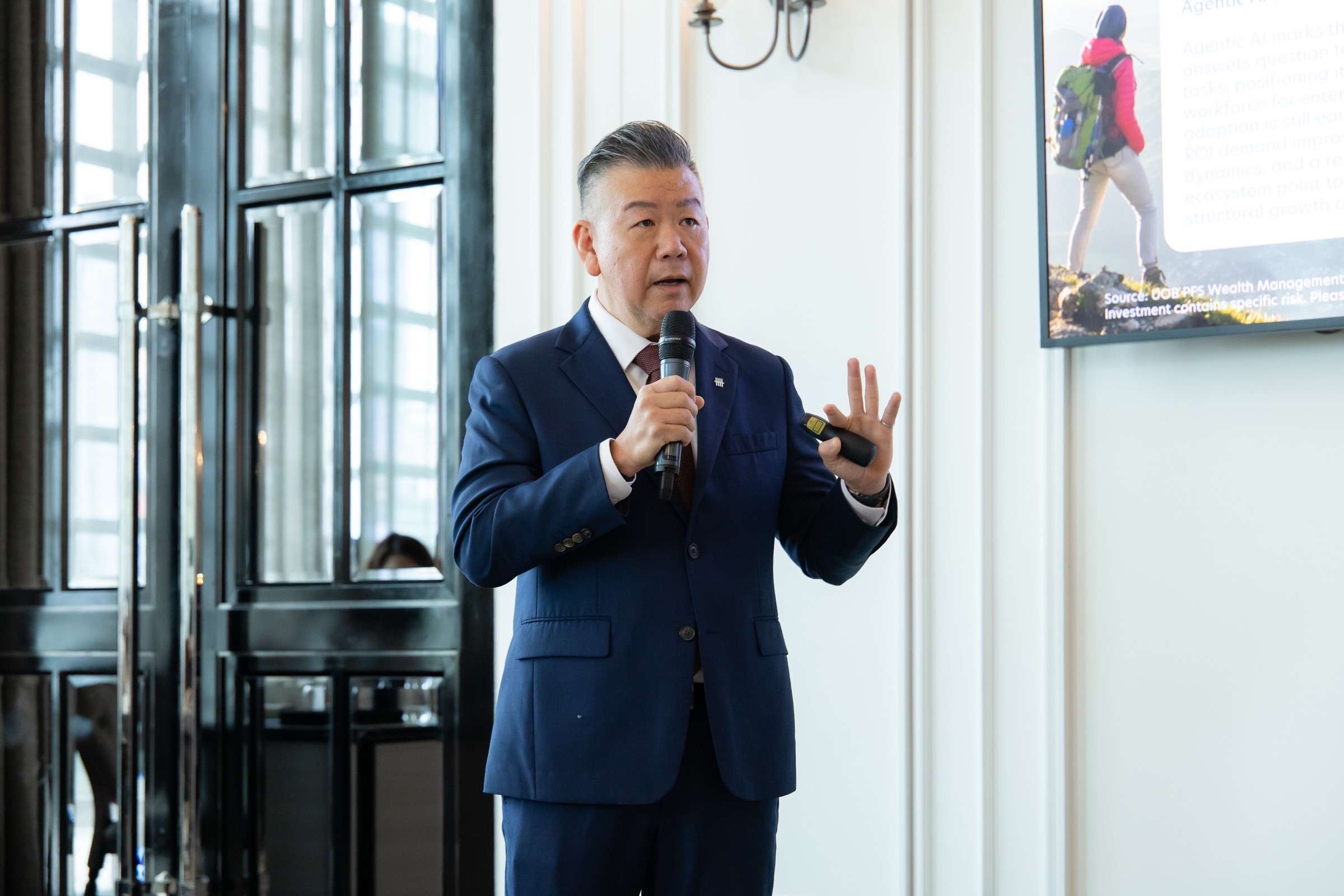 ภาพนายเอเบิล ลิม Head of Deposit and Wealth Management ธนาคารยูโอบี ประเทศไทย กำลังถือไมโครโฟนบรรยายมุมมองการลงทุนครึ่งปีหลัง 2569