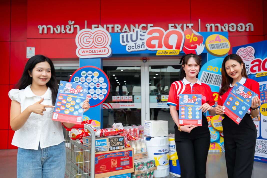GO-Wholesale-Sticker-Discount-Campaign-Launch-B2B ภาพพรีเซนเตอร์หญิง 3 คนถือแผ่นสติ๊กเกอร์ แปะอะไรก็ลด โพสท่าถ่ายรูปคู่กับรถเข็นสินค้าบริเวณหน้าทางเข้าศูนย์ค้าส่ง โก โฮลเซลล์