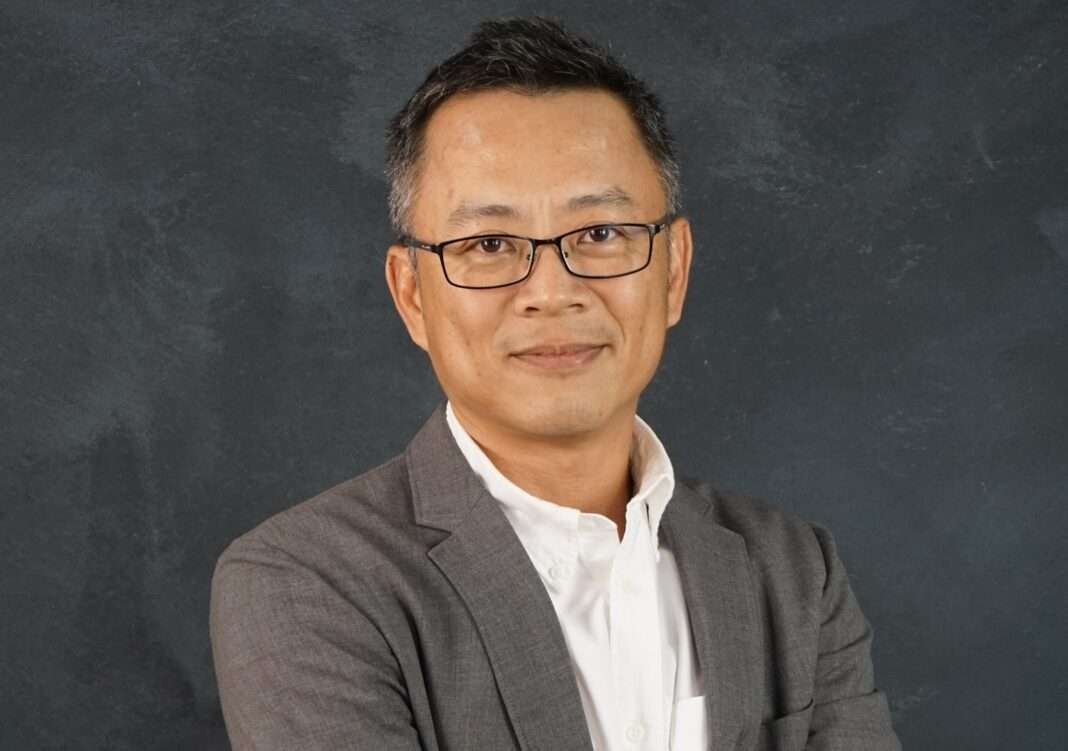 Kuna-Taywatakson-CEO-Villa-Kunalai-KUN-Business-Outlook ภาพนายคุณา เทวอักษร ประธานเจ้าหน้าที่บริหาร บริษัท วิลล่า คุณาลัย จำกัด (มหาชน) หรือ KUN สวมเสื้อเชิ้ตสีขาวทับด้วยสูทสีเทา ยืนกอดอกด้วยความมั่นใจ ถ่ายภาพพอร์ตเทรตเพื่อนำเสนอวิสัยทัศน์และทิศทางธุรกิจ
