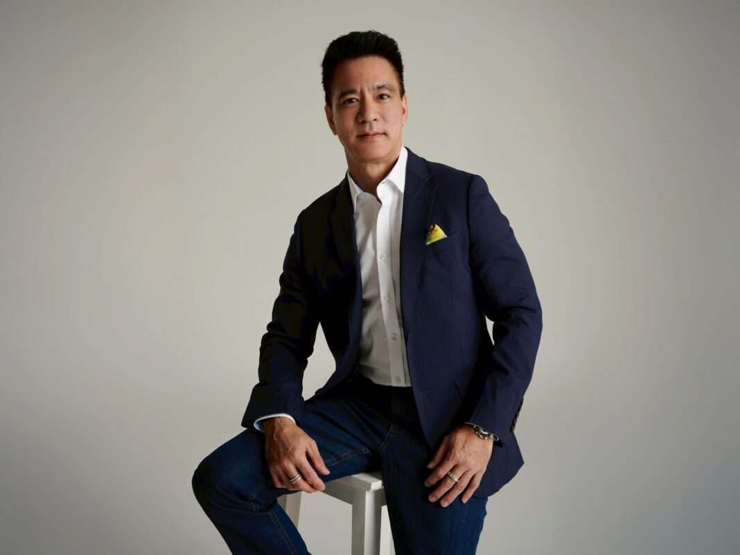 Matthew-Kichodhan-CEO-Mc-Group-MC-Financial-Results-2026 ภาพนายแมทธิว กิจโอธาน ประธานเจ้าหน้าที่บริหาร บริษัท แม็คกรุ๊ป จำกัด (มหาชน) หรือ MC สวมเสื้อสูทสีน้ำเงินเข้มทับเสื้อเชิ้ตสีขาวและกางเกงยีนส์ นั่งถ่ายภาพพอร์ตเทรตด้วยความมั่นใจ เพื่อสะท้อนภาพลักษณ์ผู้นำแบรนด์แฟชั่นไลฟ์สไตล์ในการแถลงผลประกอบการปีบัญชี 2569