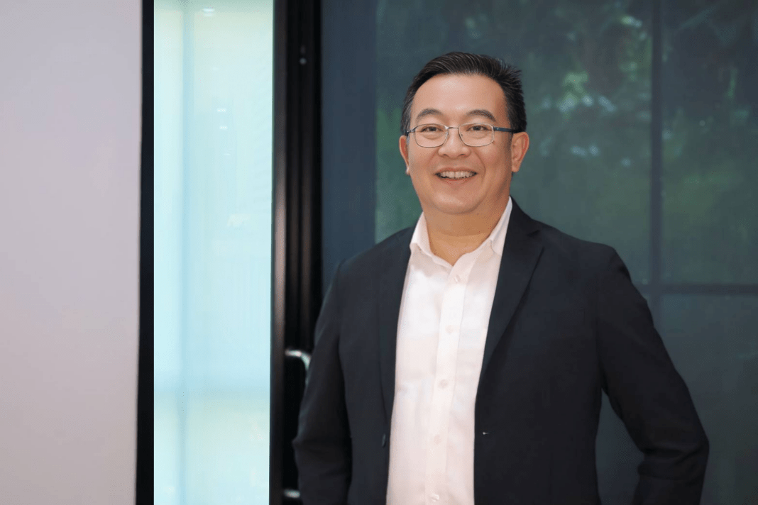 Piya-Techakul-CEO-ATP30-JUMP-Plus-Green-Mobility ภาพนายปิยะ เตชากูล ประธานเจ้าหน้าที่บริหาร บริษัท เอทีพี 30 จำกัด (มหาชน) หรือ ATP30 สวมเสื้อเชิ้ตสีขาวทับด้วยสูทสีดำ ยืนยิ้มถ่ายภาพด้วยความมั่นใจ