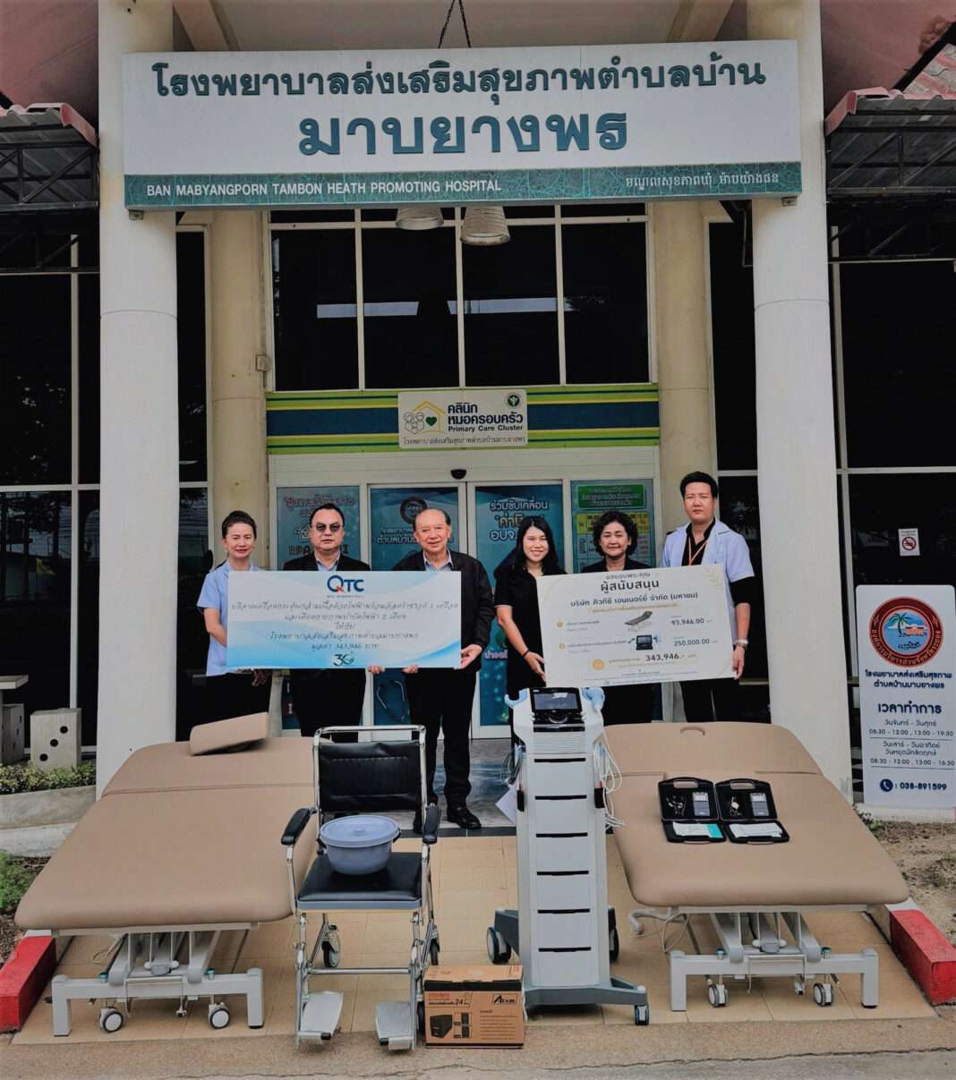 ภาพนายพูลพิพัฒน์ ตันธนสิน ประธานเจ้าหน้าที่บริหาร และกรรมการผู้จัดการ พร้อมด้วยผู้บริหารระดับสูง บริษัท คิวทีซี เอนเนอร์ยี่ จำกัด (มหาชน) หรือ QTC ร่วมกันส่งมอบป้ายสนับสนุนและอุปกรณ์การแพทย์ทางกายภาพบำบัด บริเวณหน้าโรงพยาบาลส่งเสริมสุขภาพตำบลบ้านมาบยางพร