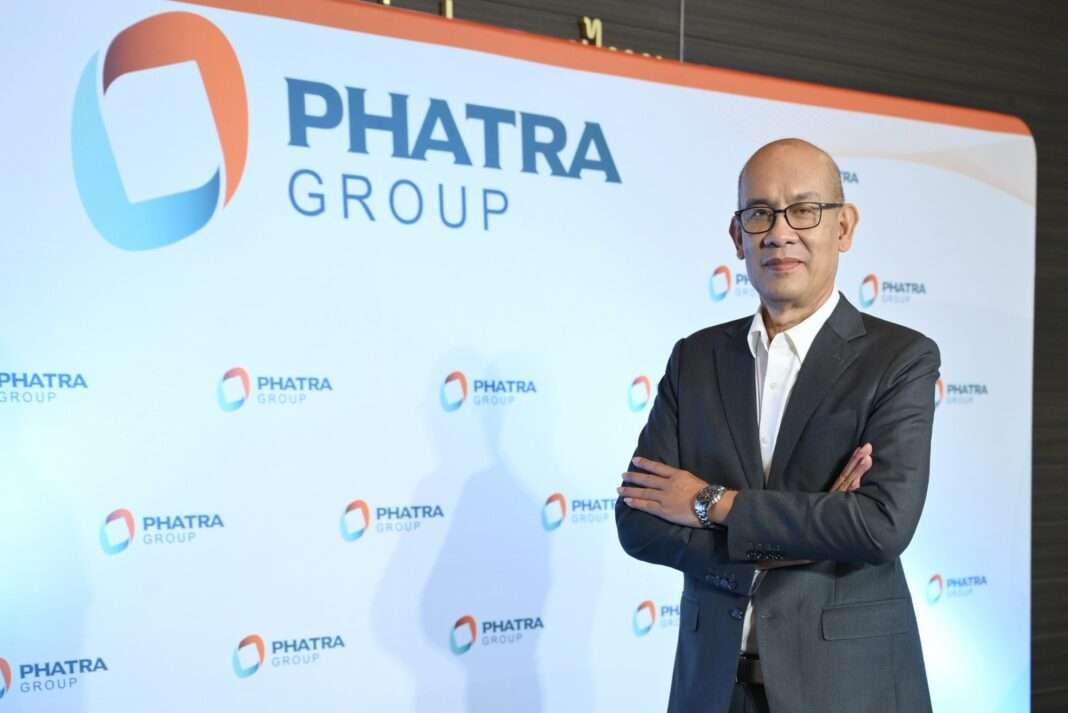 Somnuk-Chantawong-CEO-Phatra-Group-PHAT-Business-Outlook ภาพนายสมนึก จันทวงศ์ ประธานเจ้าหน้าที่บริหาร บริษัท กลุ่มภัทร จำกัด (มหาชน) หรือ PHAT สวมชุดสูทสากล ยืนกอดอกด้วยความมั่นใจ ถ่ายภาพหน้าป้ายแบคดรอป PHATRA GROUP เพื่อแถลงทิศทางธุรกิจและกลยุทธ์การขยายตลาดต่างประเทศ