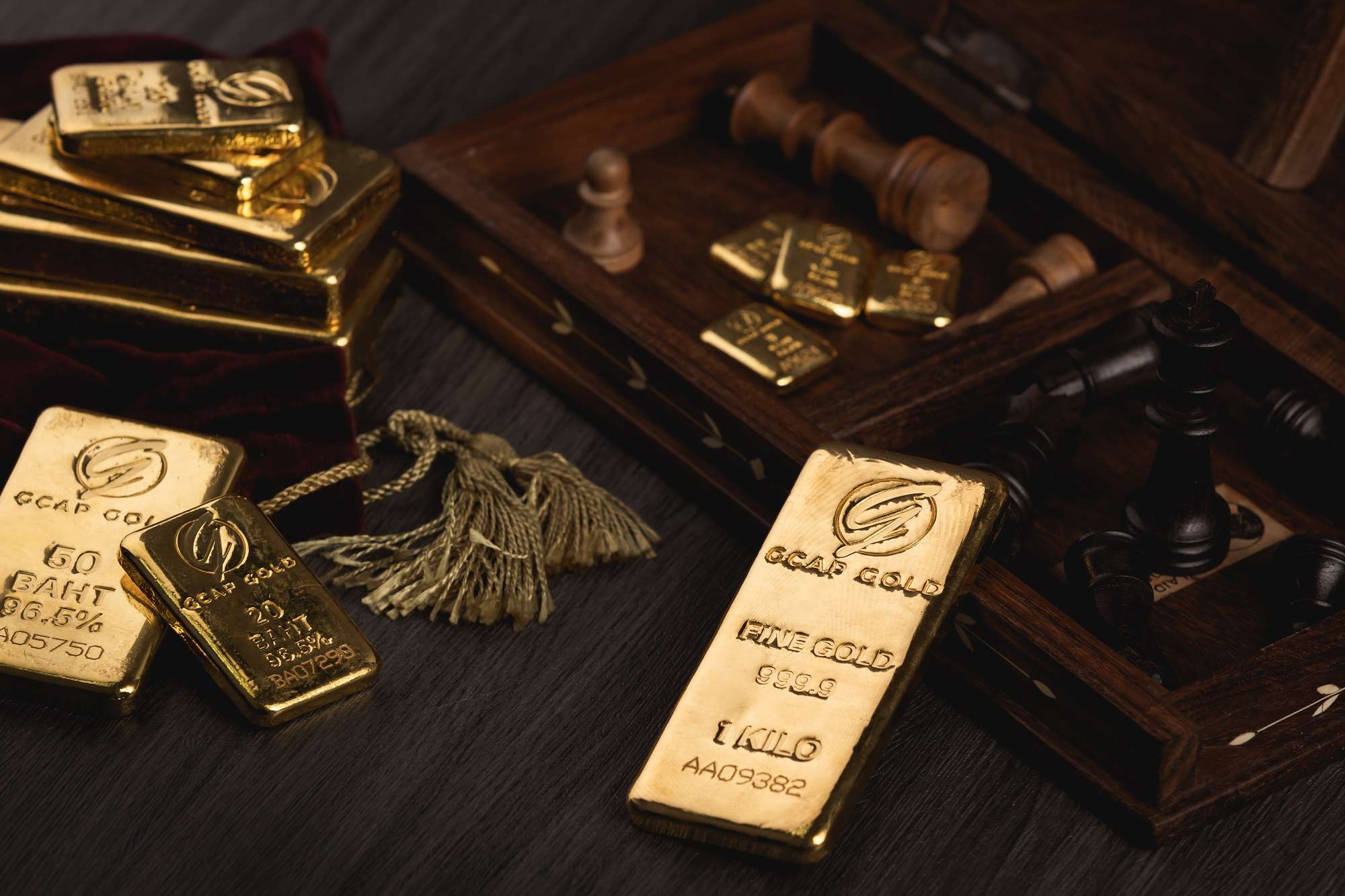 ทองคำแท่ง GCAP GOLD วางบนโต๊ะไม้พร้อมหมากรุก สื่อถึงกลยุทธ์การลงทุนทองคำ