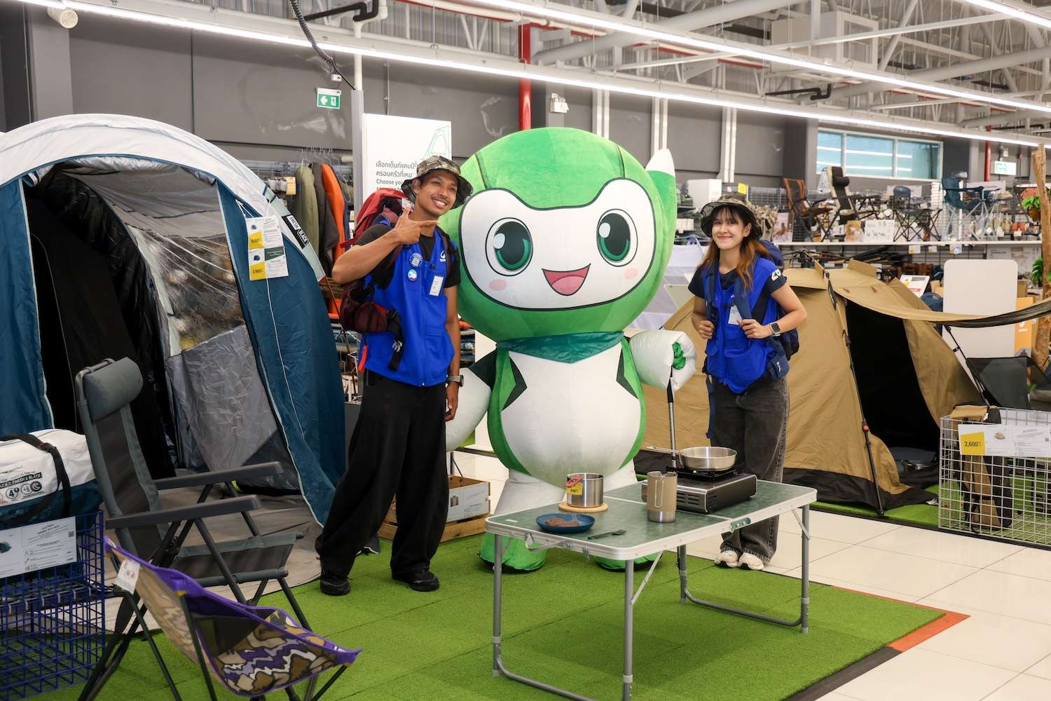 มาสคอตประกันภัยไทยวิวัฒน์และพนักงาน Decathlon ถ่ายภาพร่วมกันที่โซนอุปกรณ์แคมป์ปิ้งภายในสาขา