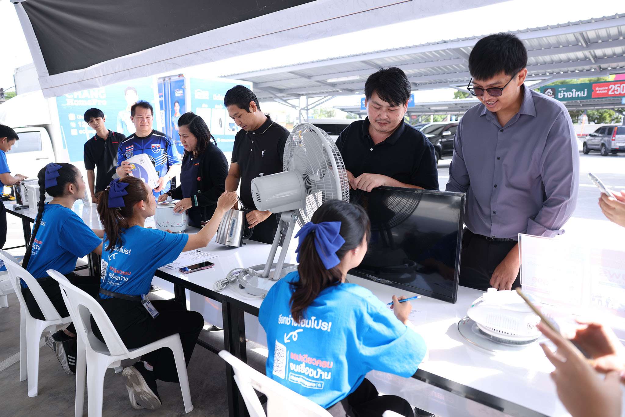 ภาพบรรยากาศประชาชนนำเครื่องใช้ไฟฟ้าที่ชำรุด เช่น พัดลม หม้อหุงข้าว และโทรทัศน์ มาลงทะเบียนเข้ารับบริการตรวจเช็กและซ่อมฟรีกับทีมงาน CHANG HomePro ที่จุดให้บริการหน้าสาขา