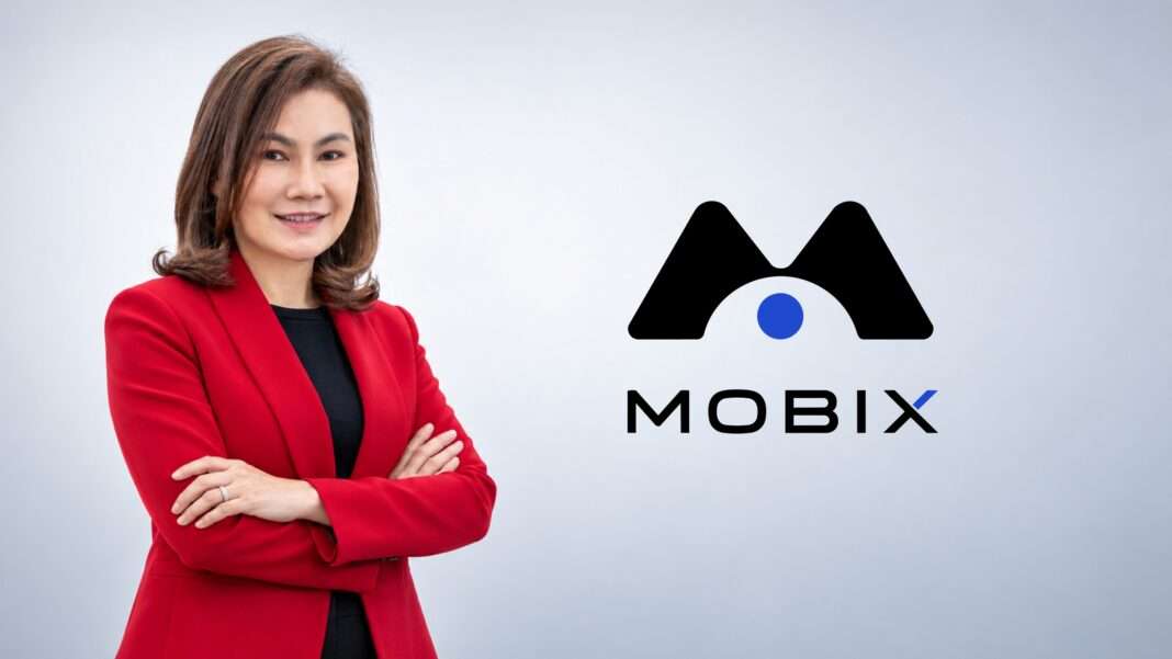 Kanthima-Jaengwansuk-CEO-SO-Siamrajathanee-MOBIX-Launch ภาพนางสาวกัณธิมา แจ้งวันสุข ประธานเจ้าหน้าที่บริหาร บริษัท สยามราชธานี จำกัด (มหาชน) หรือ SO สวมชุดสูทสีแดง ยืนกอดอกด้วยความมั่นใจ เคียงข้างโลโก้แอปพลิเคชัน MOBIX เพื่อประกาศเปิดตัวแพลตฟอร์มบริหารจัดการคนและรถยนต์
