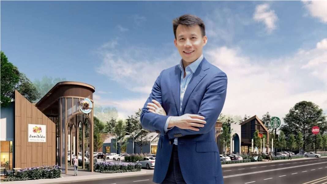 นายกวินทร์ เอี่ยมสกุลรัตน์ ประธานเจ้าหน้าที่บริหาร บริษัท อัลไล รีท แมนเนจเมนท์ จำกัด สวมชุดสูทสีน้ำเงินยืนกอดอกยิ้มด้วยความมั่นใจ ท่ามกลางบรรยากาศพื้นที่สีเขียว