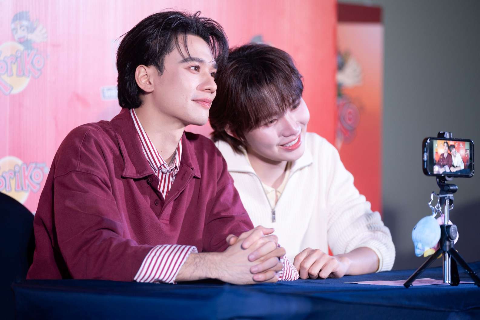 ภาพพรีเซนเตอร์ เก่ง หฤษฎ์ บัวย้อย และ น้ำปิง นภัสกร ปิงเมือง กำลังพูดคุยและทำกิจกรรมร่วมกับแฟนคลับผ่านกล้องสมาร์ตโฟน ในงาน Koriko Meet & Greet ยิ่งกล้า..ยิ่งใกล้