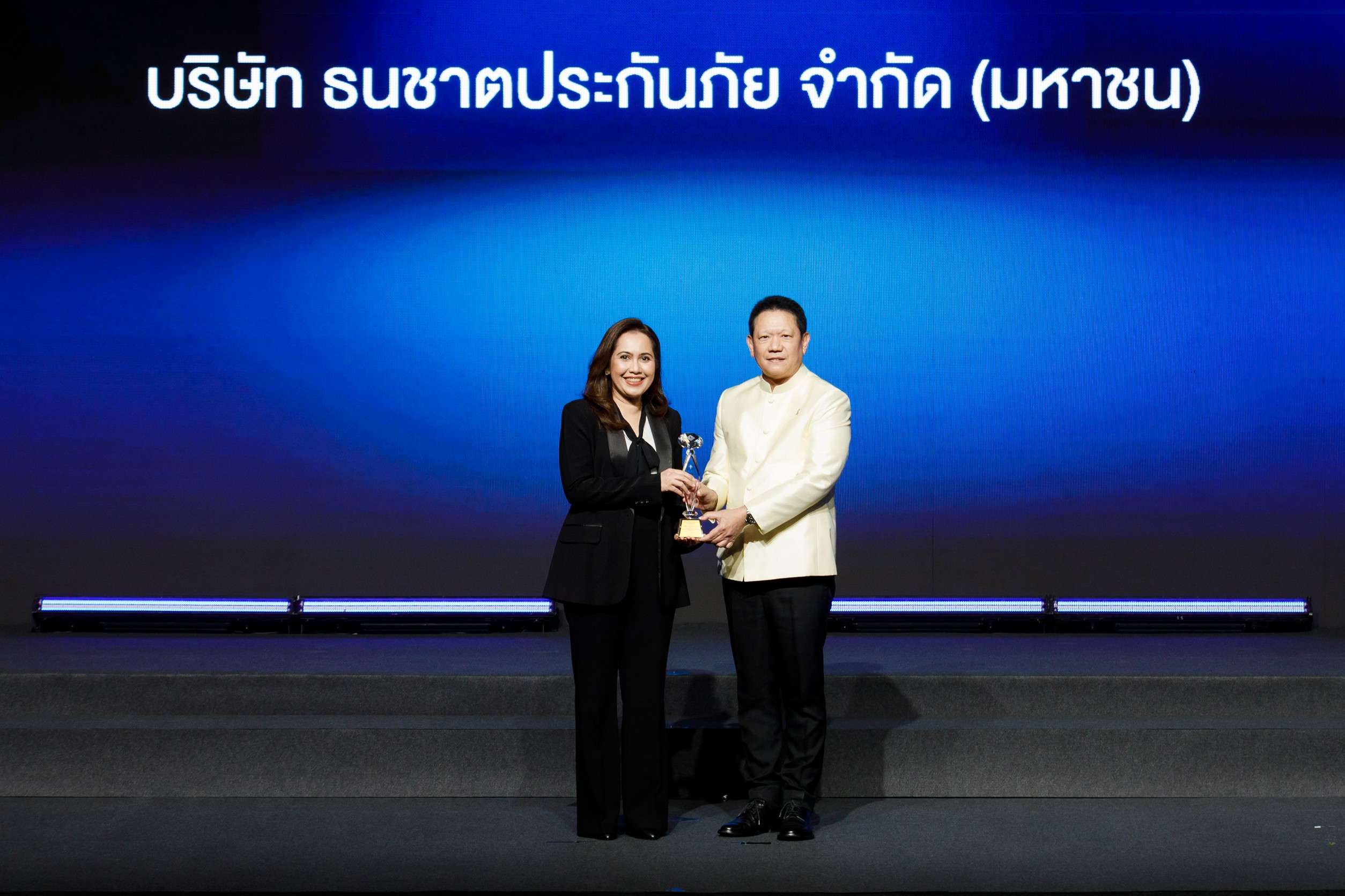 ภาพนายลวรณ แสงสนิท ปลัดกระทรวงการคลัง มอบถ้วยรางวัลเกียรติยศให้แก่นางวิชินี โอรพันธ์ ผู้บริหาร บริษัท ธนชาตประกันภัย จำกัด (มหาชน) บนเวทีงาน Prime Minister's Insurance Awards 2026