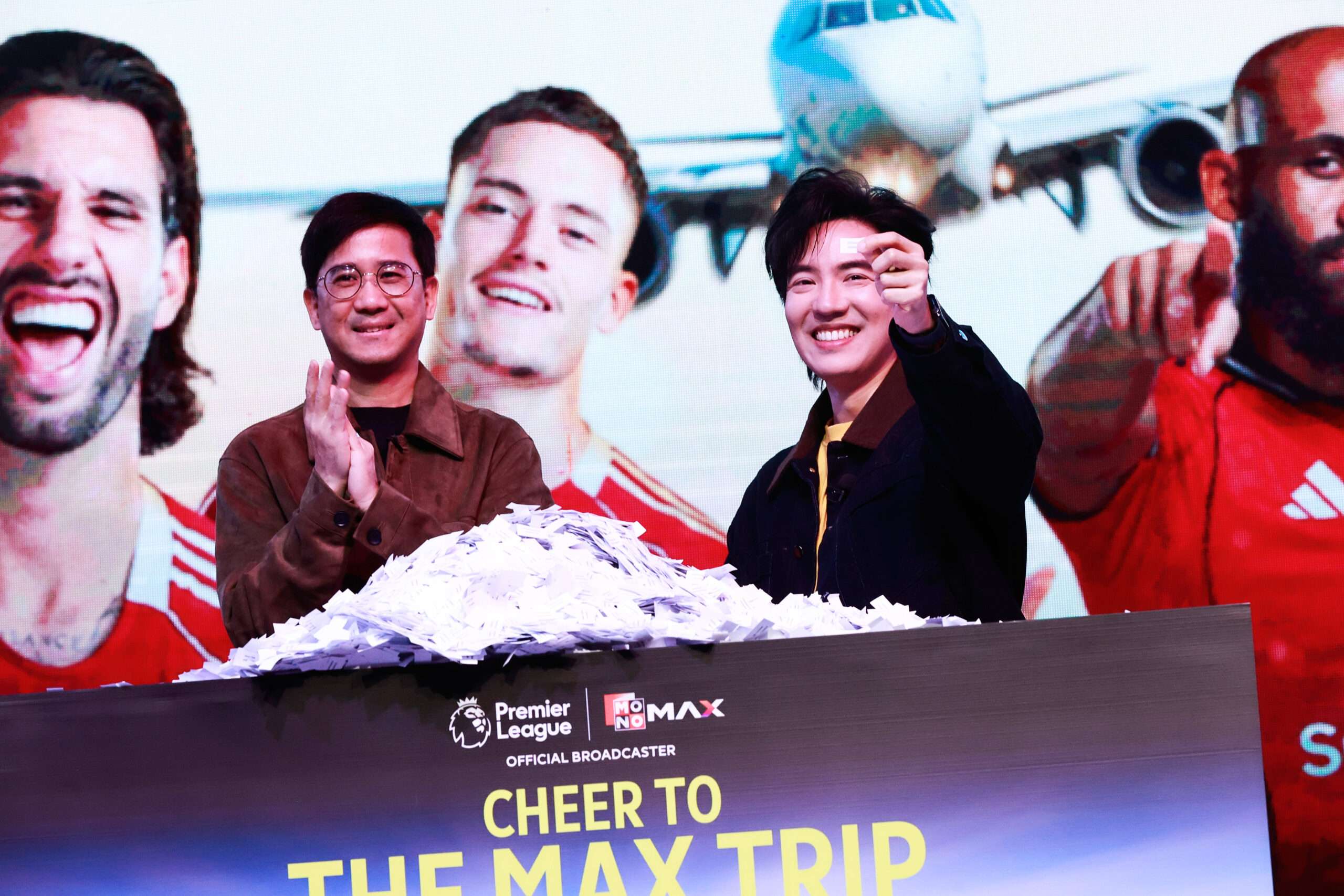 ภาพบรรยากาศการจับสลากหาผู้โชคดีบนเวทีในแคมเปญ CHEER TO THE MAX TRIP VOL.3 จัดโดยแพลตฟอร์ม MONOMAX เพื่อมอบรางวัลทริปดูฟุตบอลพรีเมียร์ลีกคู่แดงเดือดที่ประเทศอังกฤษ