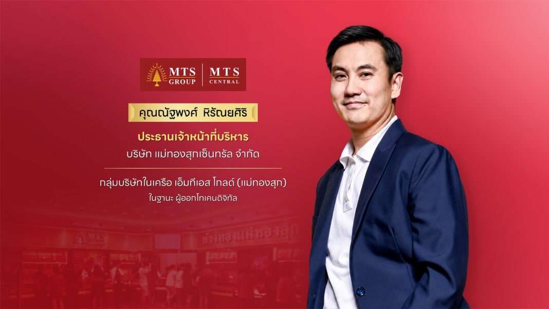 ภาพนายณัฐพงศ์ หิรัณยศิริ ประธานเจ้าหน้าที่บริหาร บริษัท แม่ทองสุกเซ็นทรัล จำกัด ในกลุ่มบริษัทในเครือ เอ็มทีเอส โกลด์ (แม่ทองสุก) ผู้ออกโทเคนดิจิทัล สวมชุดสูทสีน้ำเงินทับเสื้อเชิ้ตสีขาว ยืนอยู่บนพื้นหลังสีแดงพร้อมแสดงโลโก้แบรนด์ MTS