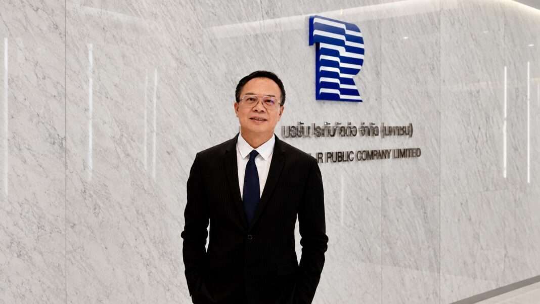 Oran-Vongsuraphichet-CEO-THRE-Thai-Reinsurance-Holding-Restructuring ภาพนายโอฬาร วงศ์สุรพิเชษฐ์ ประธานเจ้าหน้าที่บริหาร บริษัท ไทยรับประกันภัยต่อ จำกัด (มหาชน) หรือ THRE สวมชุดสูทสีดำ ยืนโพสท่าด้วยความมั่นใจบริเวณหน้าโลโก้บริษัท เพื่อประกาศความคืบหน้าการปรับโครงสร้างเป็นโฮลดิ้งคอมพานี