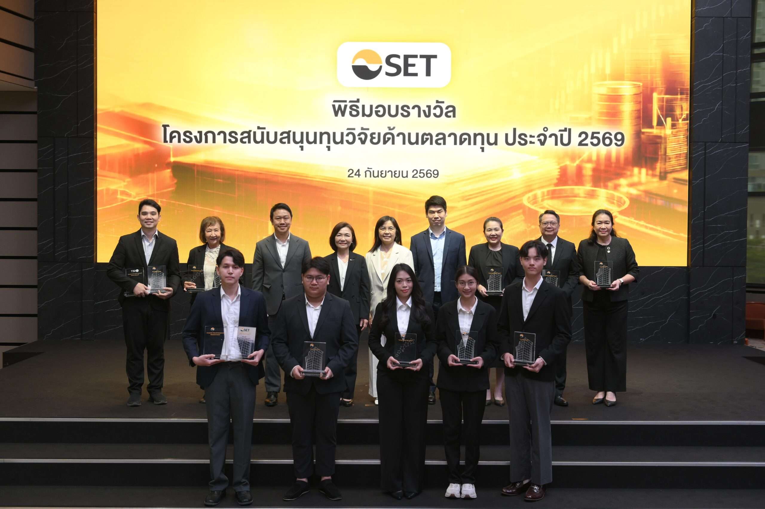 ภาพหมู่คณะผู้บริหารและผู้ได้รับรางวัลในพิธีมอบรางวัลโครงการสนับสนุนทุนวิจัยด้านตลาดทุน ประจำปี 2569 จัดโดยตลาดหลักทรัพย์แห่งประเทศไทย ถ่ายภาพร่วมกันบนเวที