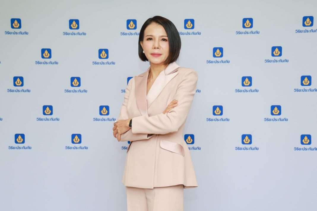 Thawikarn-Techataweesup-Assistant-Managing-Director-Viriyah-Insurance ภาพนางฐวิกาญจน์ เตชทวีทรัพย์ ผู้ช่วยกรรมการผู้จัดการ บริษัท วิริยะประกันภัย จำกัด (มหาชน) สวมชุดสูทสีโอรส ยืนกอดอกด้วยความมั่นใจ โดยมีฉากหลังเป็นโลโก้วิริยะประกันภัย