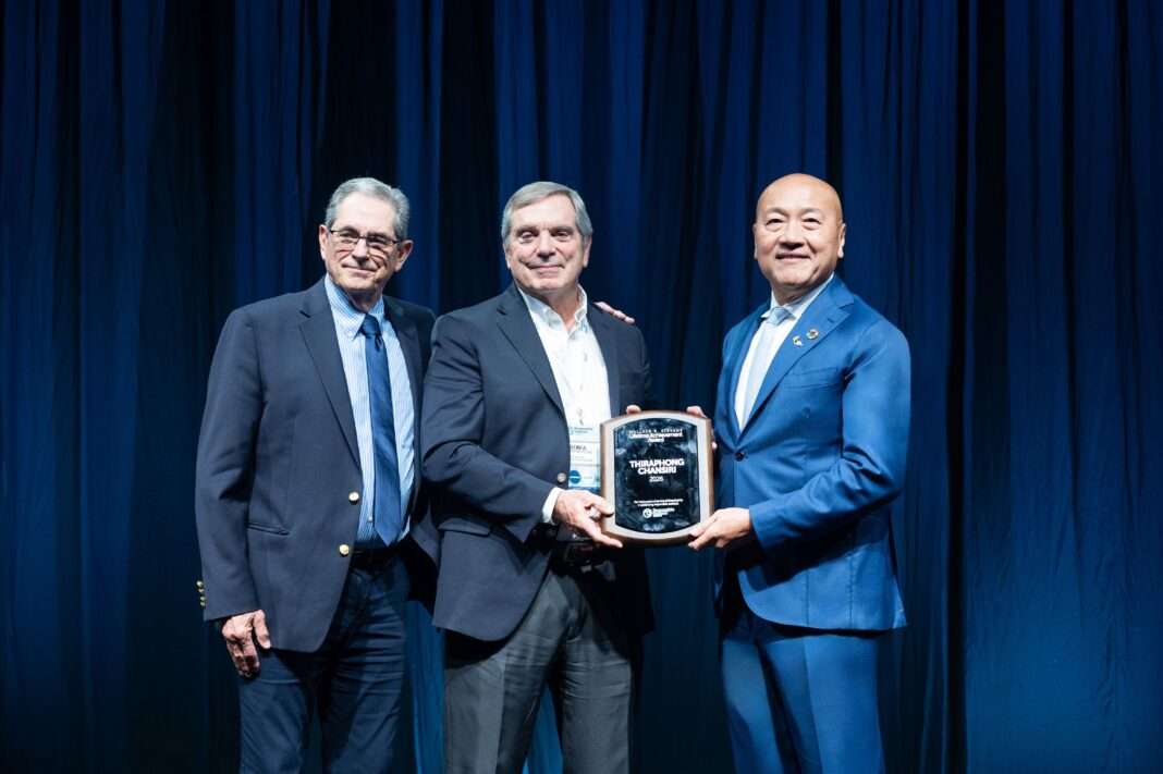 Thiraphong-Chansiri-CEO-Thai-Union-GSA-Lifetime-Achievement-Award ภาพนายธีรพงศ์ จันศิริ ประธานเจ้าหน้าที่บริหาร บริษัท ไทยยูเนี่ยน กรุ๊ป จำกัด (มหาชน) สวมชุดสูทสีน้ำเงิน ยืนรับมอบโล่รางวัล Wallace R. Stevens Lifetime Achievement Award จากตัวแทนผู้บริหารสมาคม Global Seafood Alliance (GSA) บนเวทีงาน Responsible Seafood Summit 2026