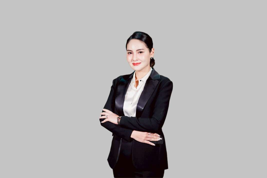 นางสาวกาญจนา พงศ์พัฒนะเดชา ประธานเจ้าหน้าที่บริหาร บริษัท เคที เมดิคอล เซอร์วิส จำกัด (มหาชน) หรือ KTMS สวมชุดสูทสีดำทับเสื้อเชิ้ตสีขาว ยืนกอดอกด้วยความมั่นใจ