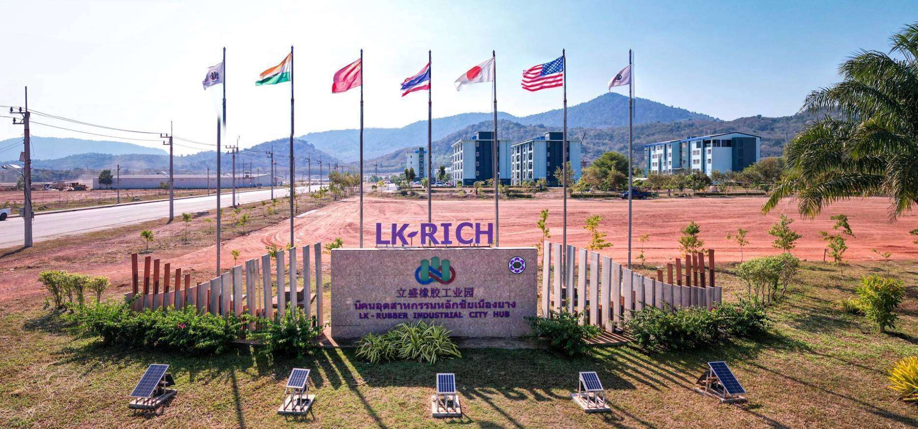 ป้ายทางเข้านิคมอุตสาหกรรมหลักชัยเมืองยาง หรือ LK-RICH ประดับด้วยธงชาติจากหลายประเทศ ได้แก่ อินเดีย จีน ไทย ญี่ปุ่น และสหรัฐอเมริกา บ่งบอกถึงการรองรับนักลงทุนต่างชาติ ท่ามกลางทัศนียภาพพื้นที่กว้างขวาง
