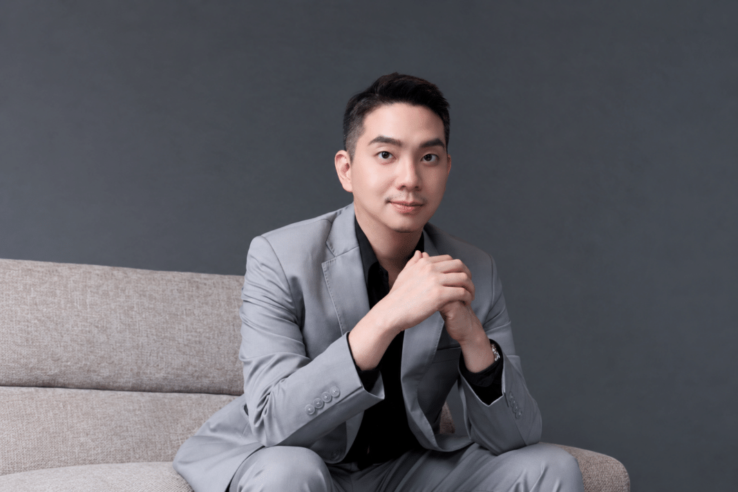 Maruay-Tangmitpracha-Dohome-Executive-Director-Brand-Campaign นายมารวย ตั้งมิตรประชา กรรมการบริหาร บริษัท ดูโฮม จำกัด (มหาชน) สวมชุดสูทสีเทา นั่งถ่ายภาพด้วยความมั่นใจ