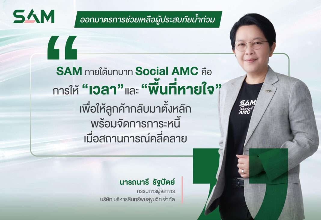 นางสาวนารถนารี รัฐปัตย์ กรรมการผู้จัดการ บริษัท บริหารสินทรัพย์สุขุมวิท จำกัด (บสส.) หรือ SAM สวมเสื้อสูทสีเทายืนยิ้มแย้มพร้อมข้อความโควตการให้ความช่วยเหลือผู้ประสบภัยน้ำท่วมภายใต้บทบาท Social AMC