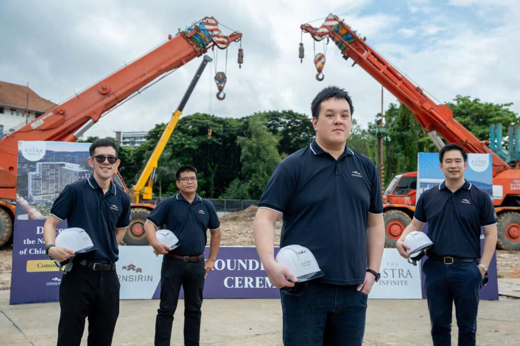 Ornsirin-CEO-Preedikorn-Buranupakorn-Groundbreaking-The-Astra-Infinite นายปรีดิกร บูรณุปกรณ์ ประธานเจ้าหน้าที่บริหาร พร้อมคณะผู้บริหาร บริษัท อรสิริน โฮลดิ้ง จำกัด (มหาชน) สวมชุดโปโลสีกรมท่า ถือหมวกนิรภัย ถ่ายภาพร่วมกันบริเวณพื้นที่ก่อสร้างโครงการโดยมีรถเครนอยู่ด้านหลัง