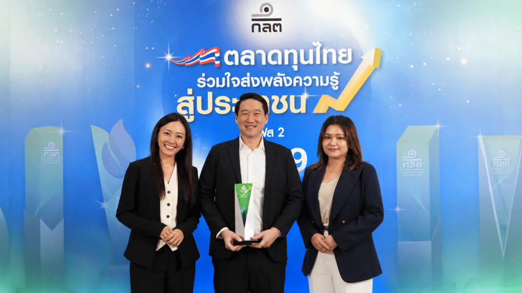 นายสานุพงศ์ สุทัศน์ธรรมกุล กรรมการผู้จัดการ บริษัทหลักทรัพย์ ฟิลลิป (ประเทศไทย) จำกัด (มหาชน) พร้อมทีมงาน ถ่ายภาพร่วมกันพร้อมถือถ้วยรางวัลความคิดสร้างสรรค์ยอดเยี่ยม บริเวณหน้าแบคดรอปงานของ ก.ล.ต.