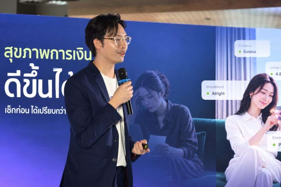 ภาพนายราเมษฐ์ ศศิรัชพรชัย หัวหน้าฝ่าย Product Owner สาย Digital and Innovation Management ธนาคารเกียรตินาคินภัทร ยืนถือไมโครโฟนบรรยายบนเวทีที่มีฉากหลังแสดงข้อความ สุขภาพการเงินดีขึ้นได้ เช็กก่อนได้เปรียบกว่า พร้อมกราฟิกแอปพลิเคชัน KKP Better