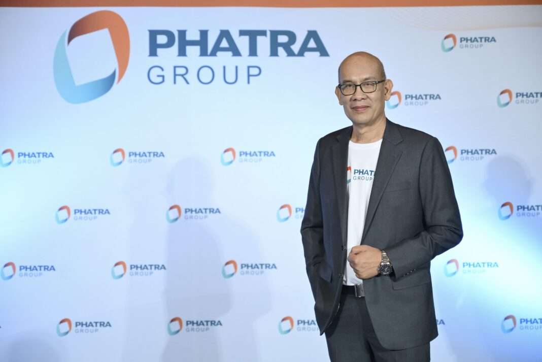 Somnuek-Chantawong-CEO-PHAT-Group-CPKO-Factory ภาพนายสมนึก จันทวงศ์ ประธานเจ้าหน้าที่บริหาร บริษัท กลุ่มภัทร จำกัด (มหาชน) หรือ PHAT สวมเสื้อสูทสีเทาทับเสื้อยืดสีขาว ยืนโพสท่าด้วยความมั่นใจ โดยมีฉากหลังเป็นป้ายโลโก้ PHAT GROUP