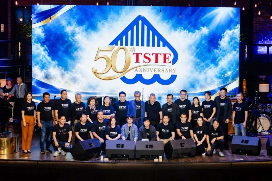 TSTE-50th-Anniversary-Next-Move-Together-Celebration ภาพคณะผู้บริหารระดับสูงและพนักงาน บริษัท ทีเอสทีอี จำกัด (มหาชน) สวมเสื้อยืดสีดำสกรีนโลโก้ TSTE ถ่ายภาพหมู่ร่วมกันบนเวทีที่มีฉากหลังหน้าจอ LED ขนาดใหญ่แสดงโลโก้ 50th TSTE Anniversary