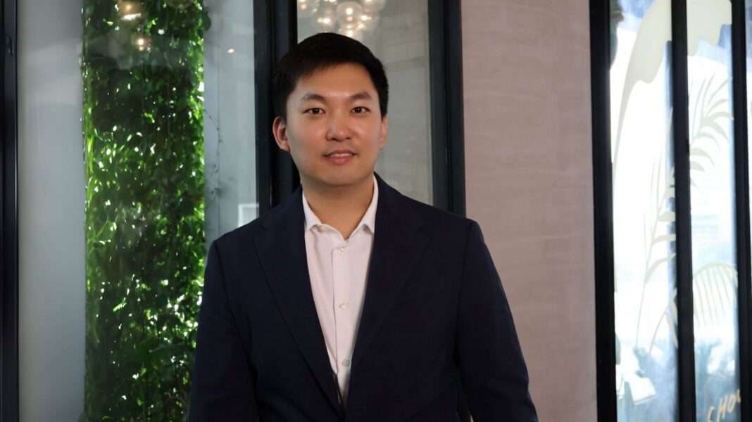 Wuthisin-Jaratborvornpan-CEO-Puean-Tae-Capital-PUEAN-Corporate-Bond ภาพถ่ายครึ่งตัวของนายวุฒิศิลป์ จรัสบวรพันธ์ ประธานเจ้าหน้าที่บริหาร บริษัท เพื่อนแท้ แคปปิตอล จำกัด หรือ PUEAN สวมเสื้อสูทสีน้ำเงินเข้มทับเสื้อเชิ้ตสีขาว ยืนส่งรอยยิ้มอย่างมั่นใจ
